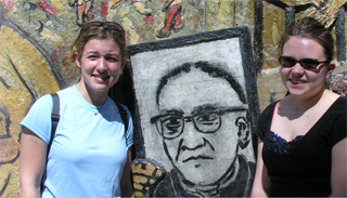 two girls standing in front of mural