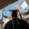 person wearing graduation cap and gown facing away from camera